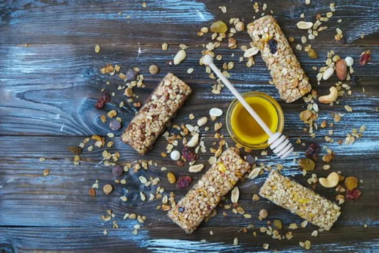 Homemade granola bars with a jar of honey